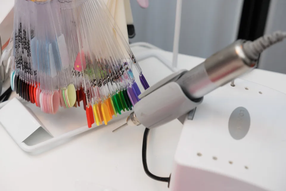 Farbpalette mit Gel-Lack-Mustern und Fräser am Arbeitsplatz im Nagelstudio Düsseldorf